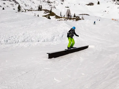 Snowboarder auf einem Rail im Funpark