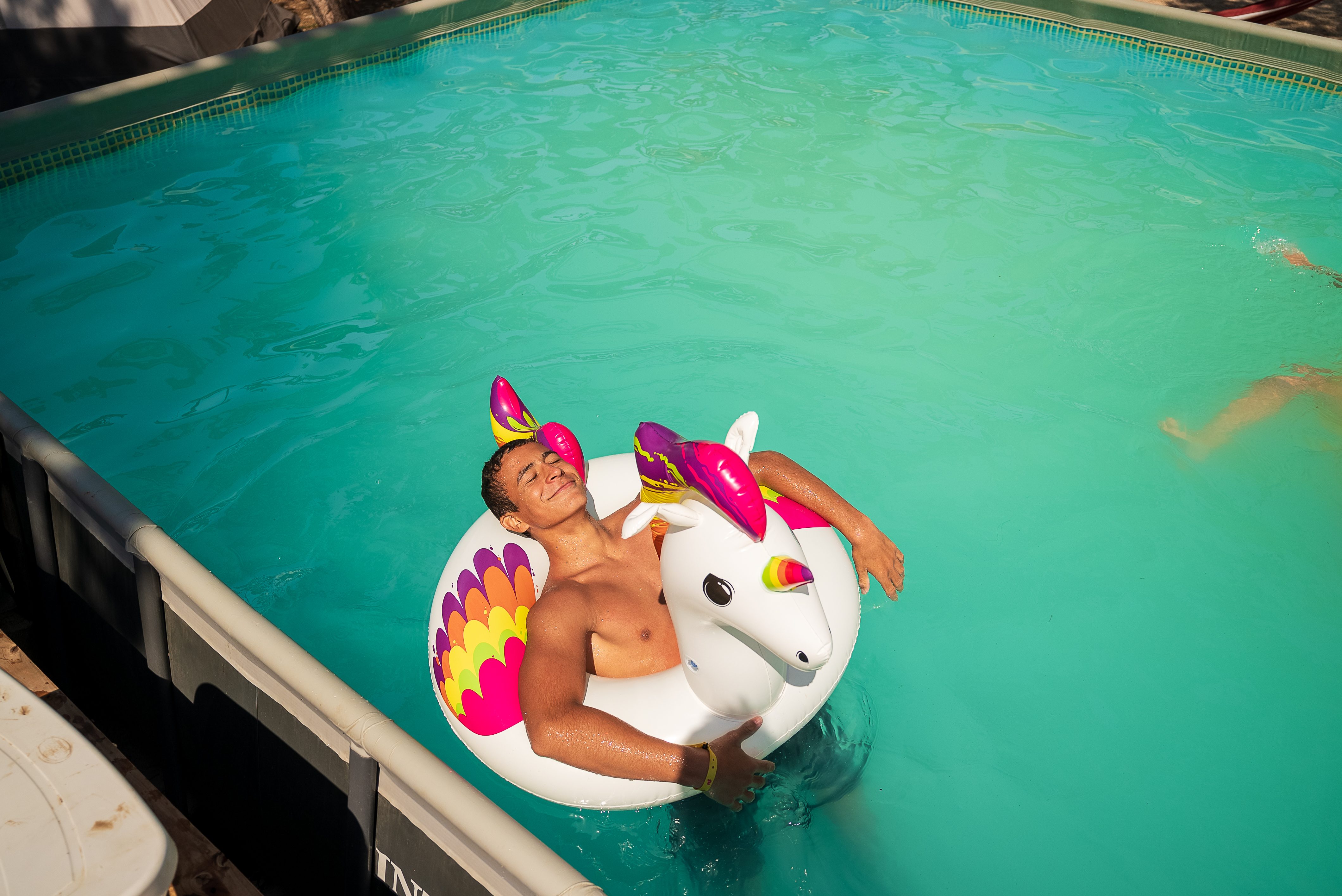 ruf Gast sonnst sich im Pool in einem Schwimmring