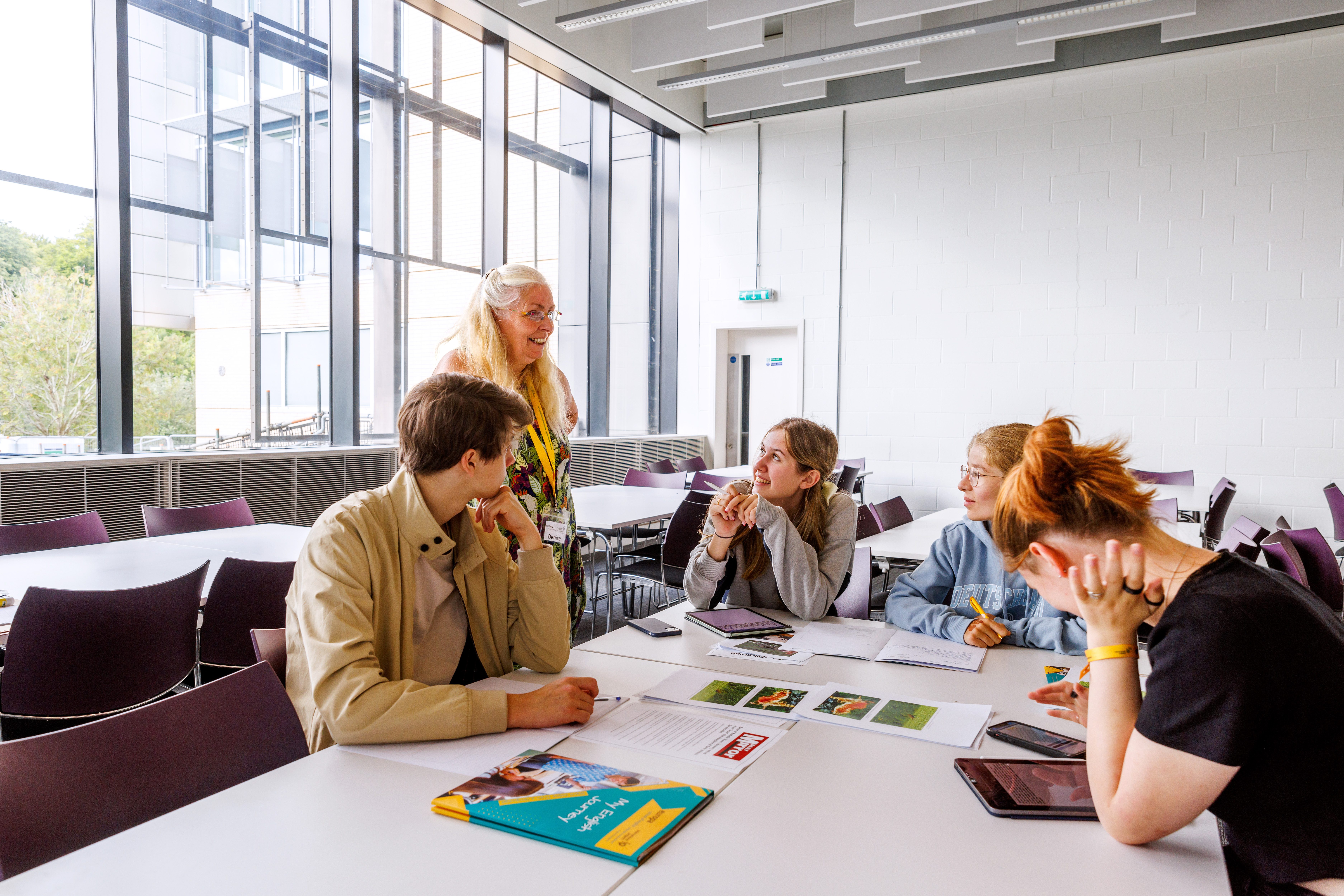 Klassenraum mit Schülern und Lehrerin im Gespräch