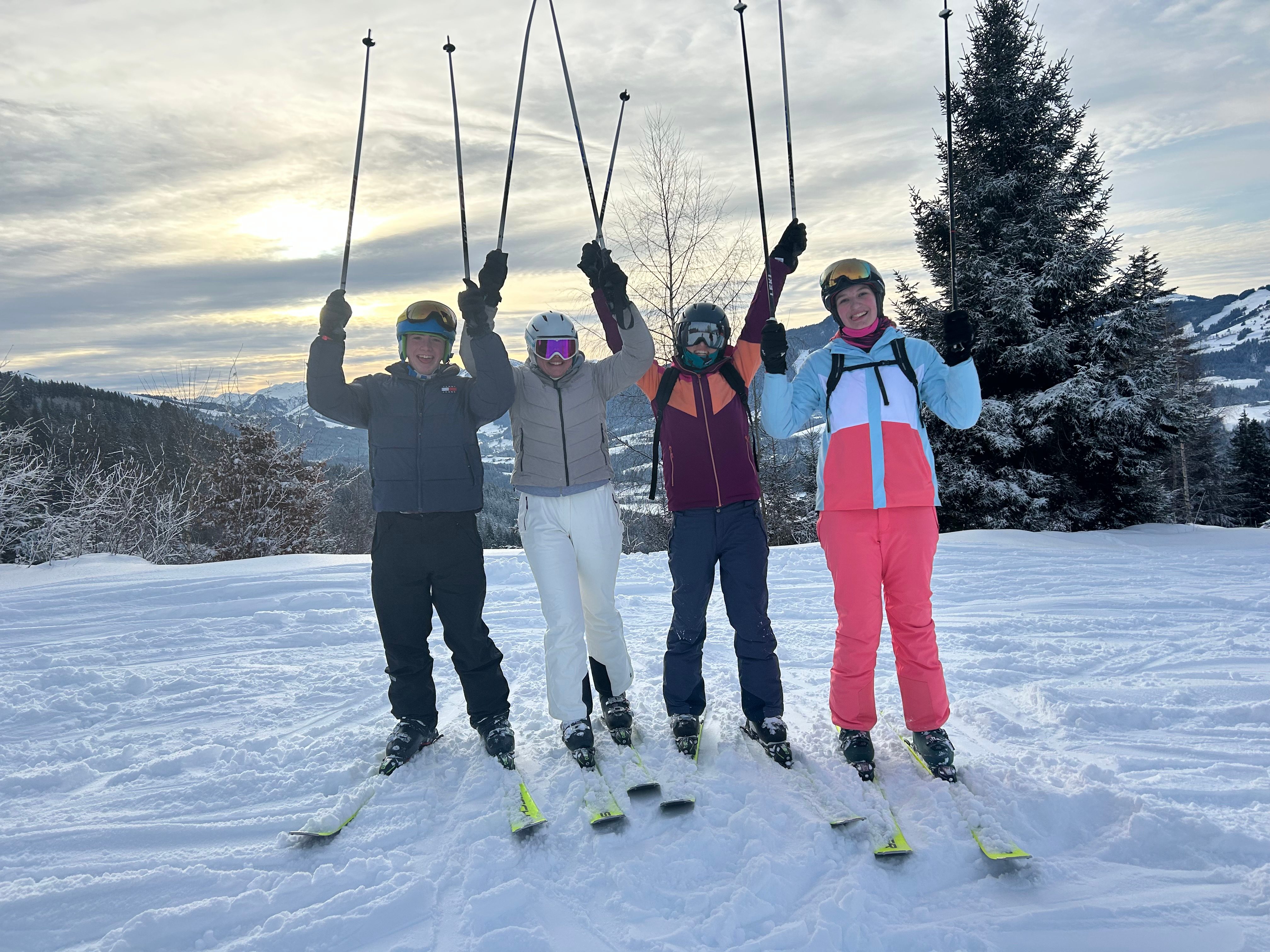 Gruppe posiert für ein Foto im Schnee mit Skistöcken in der Hand