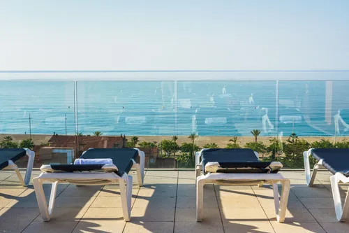Dachterrasse mit Liegen und Aussicht auf das Meer
