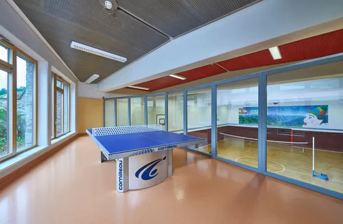 Tischtennisplatte und im Hintergrund Sporthalle vom Gästehaus Niederegg