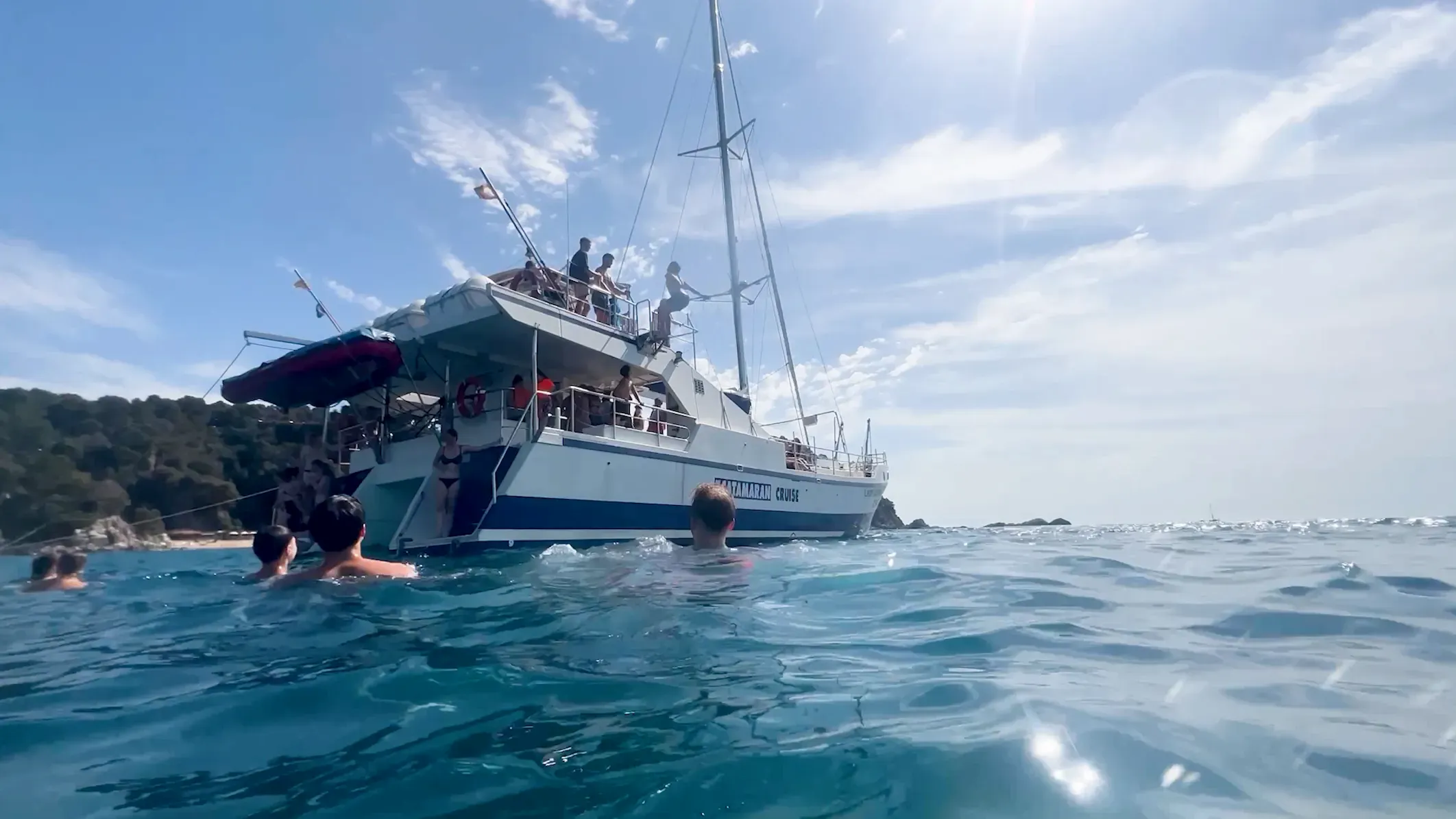 Jugendliche springen ins Meer beim Katamaranausflug