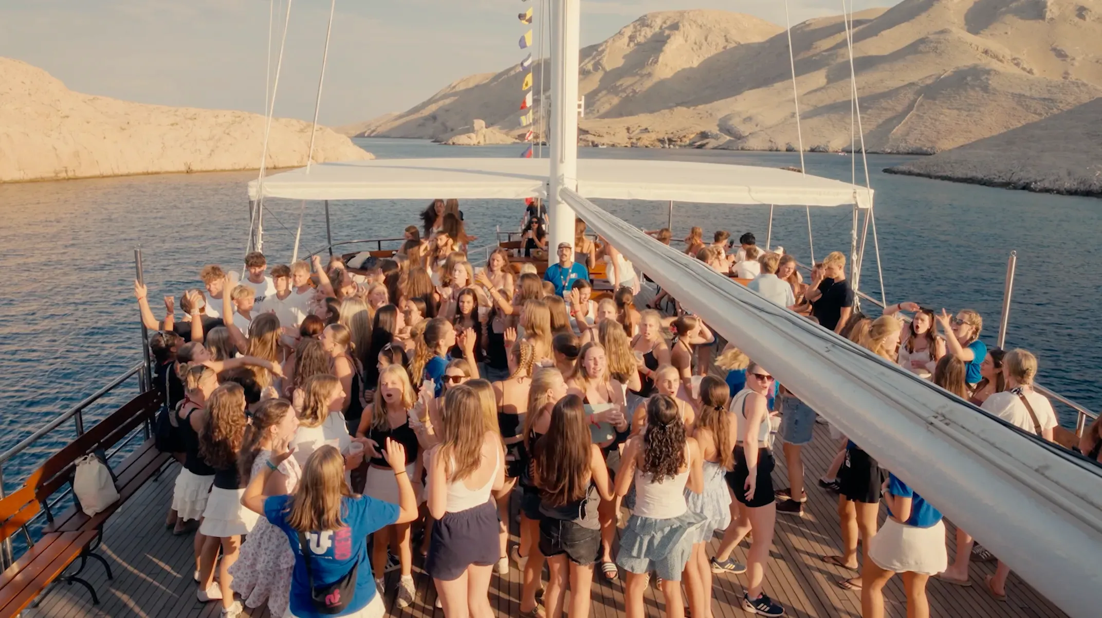 Jugendliche tanzen auf dem Catamaran bei Sonnenuntergang