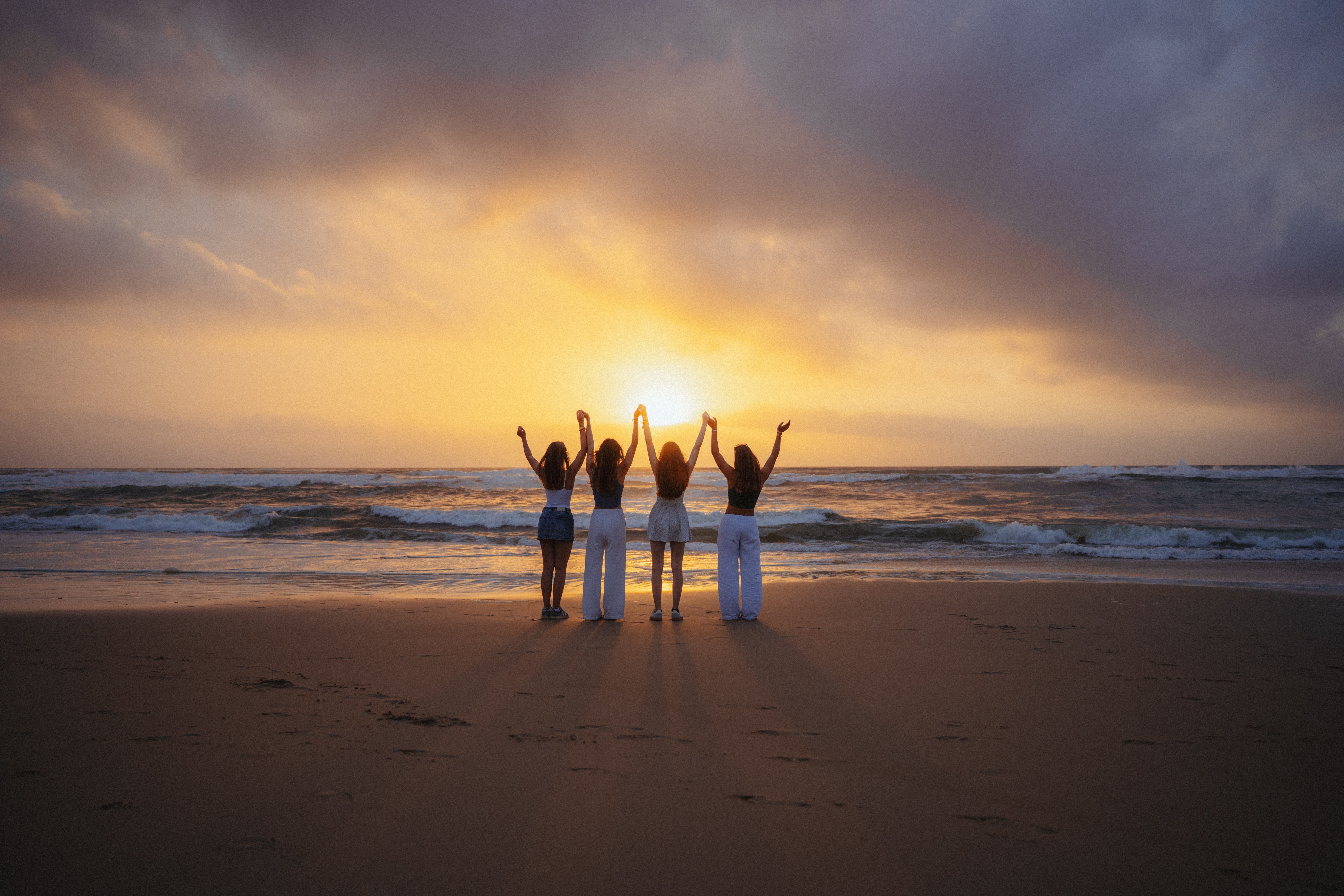 Gäste am Strand beim Sonnenuntergang