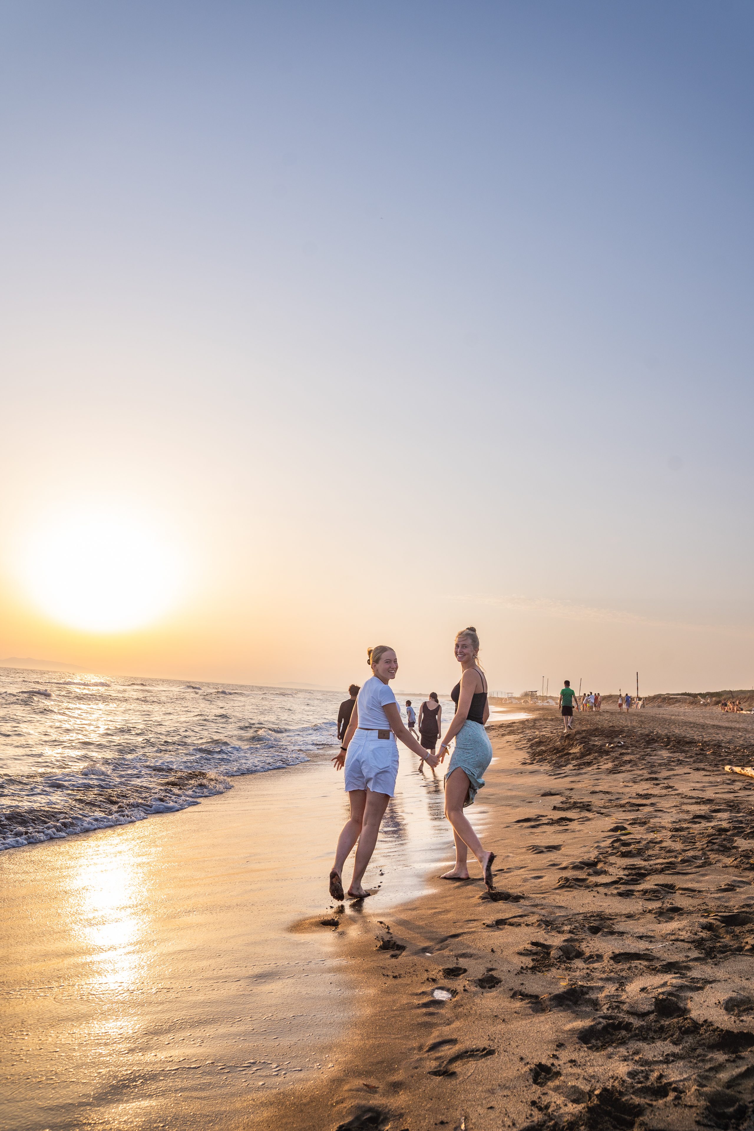 Gäste am Strand im Sonnenuntergang