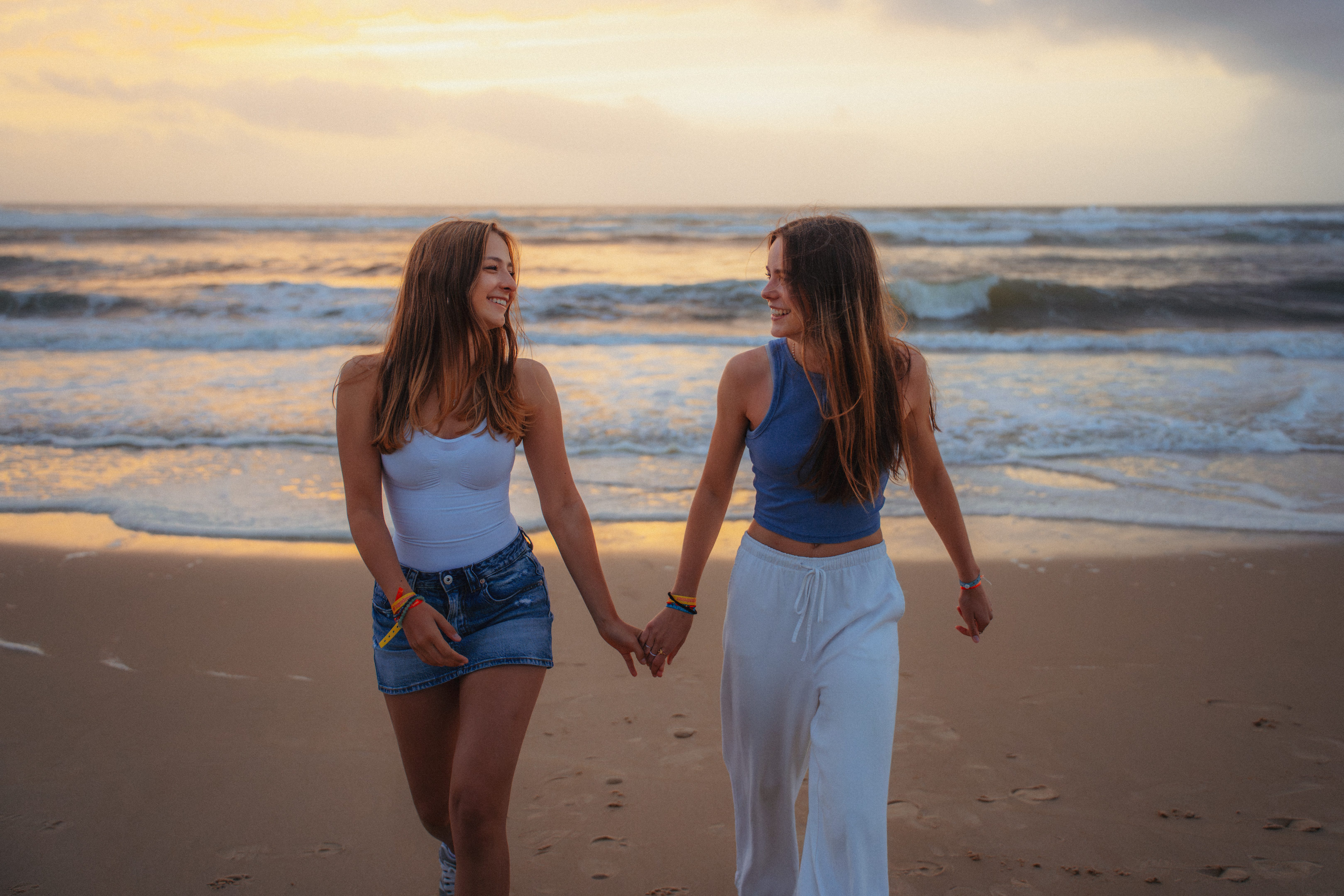 2 Mädchen halten Hände am Strand